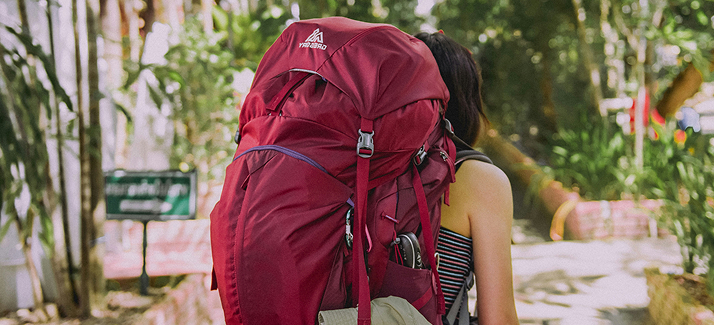 vrouw met rode backpack op haar rug