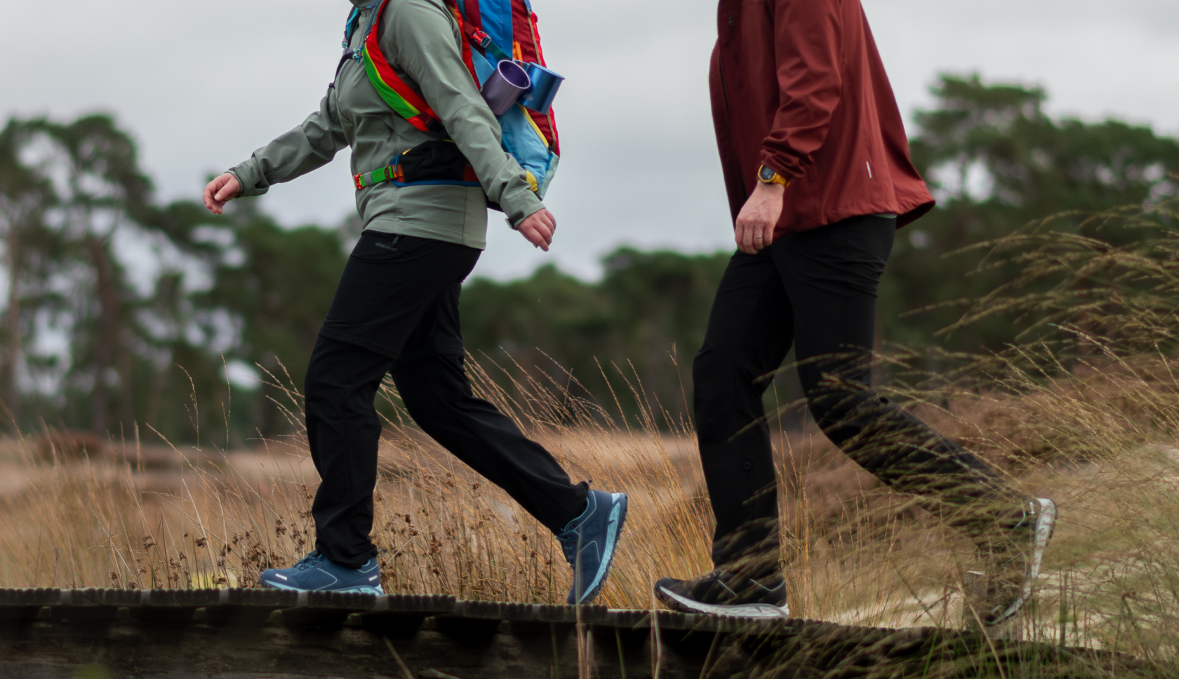 twee wandelaars in wandelschoenen van meindl lopen over houten steigers