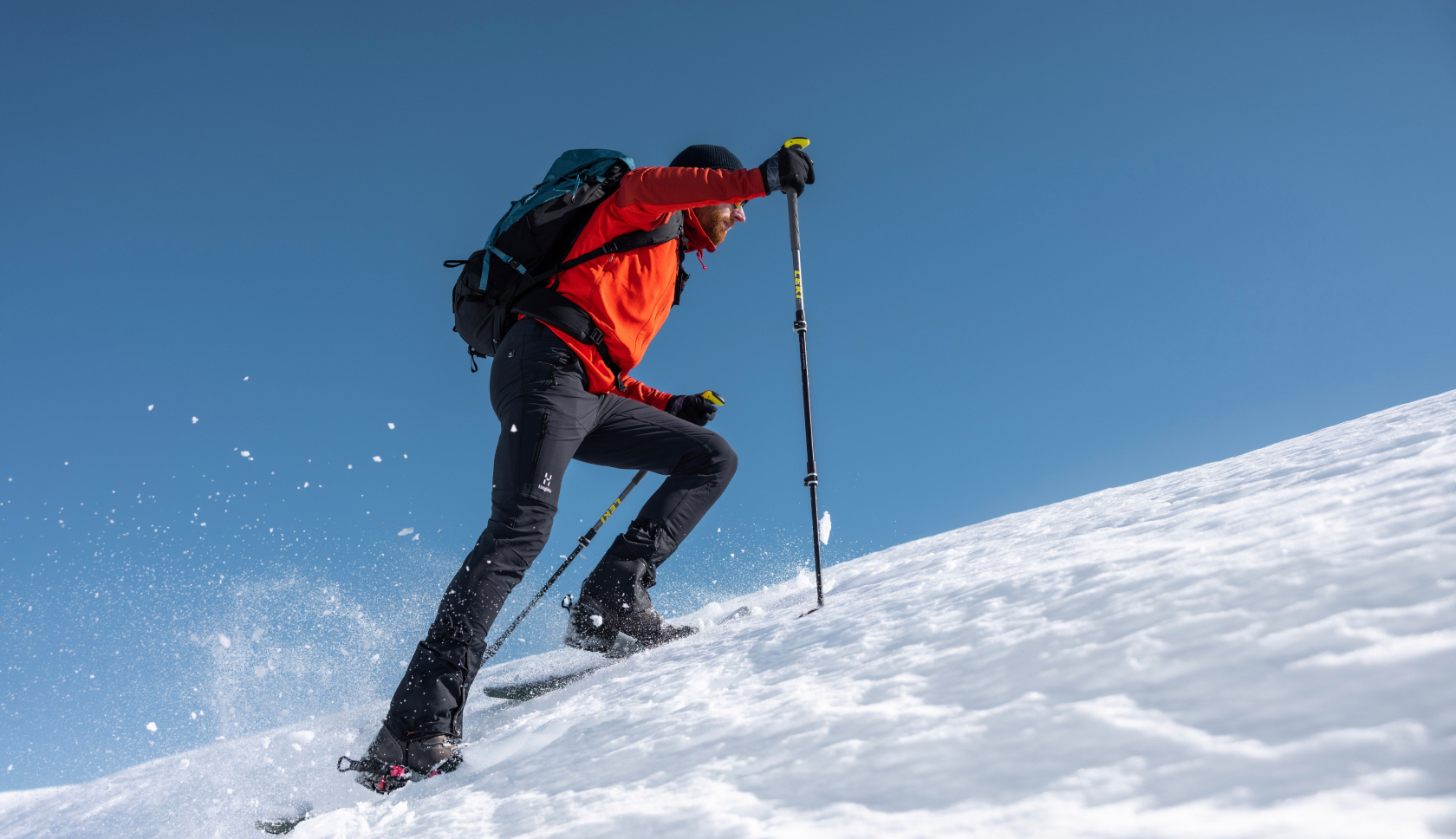 man in sneeuwschoenen wandelt over besneeuwde berg