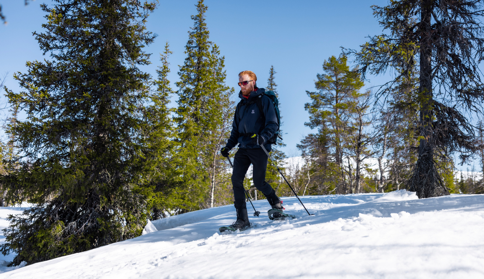 man in sneeuschoenen wandelt over besneeuwde berg