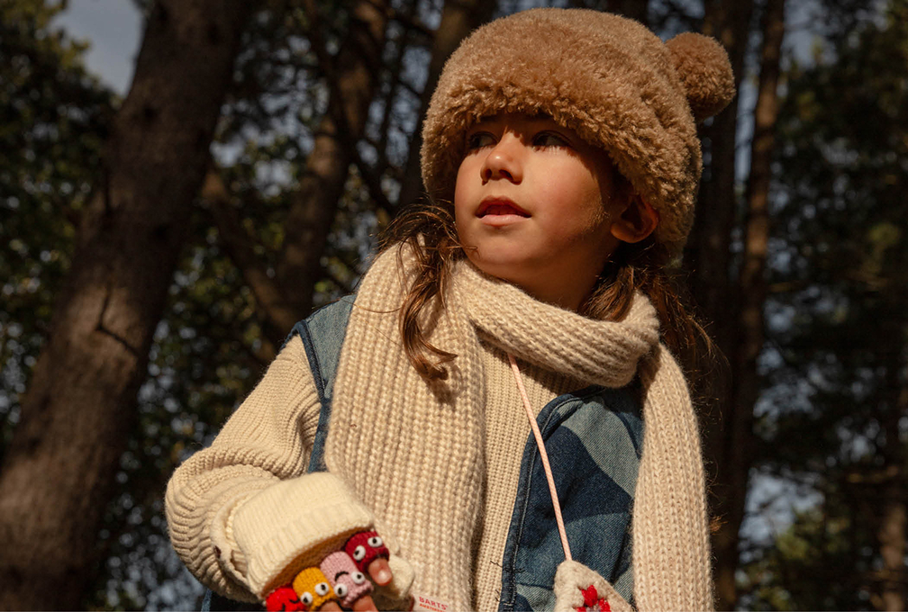 kind in een dikke sjaal en een warme muts