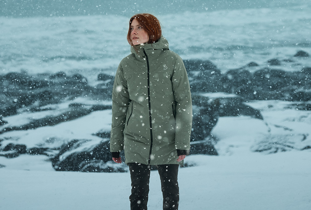 roodharige vrouw staart voor zich uit in de sneeuw