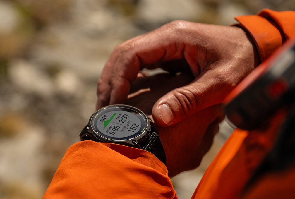 man met feloranje jas draagt een garmin smartwatch