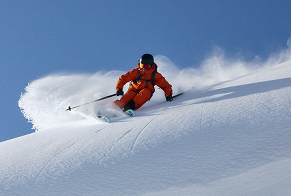 man in rood skipak slalomt naar beneden