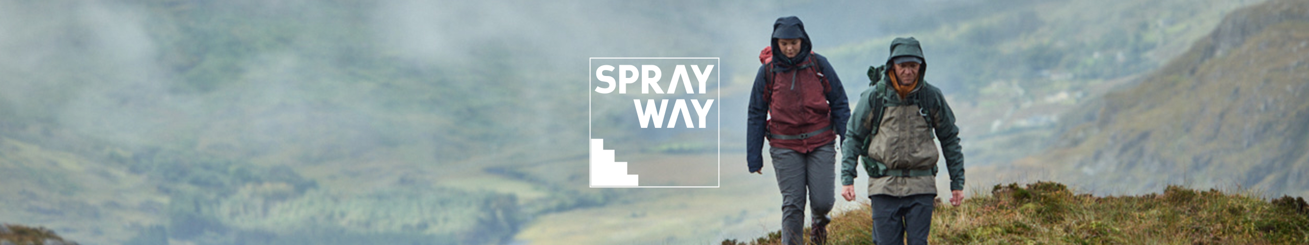 twee mensen in regenjassen wandelen door grassige bergen