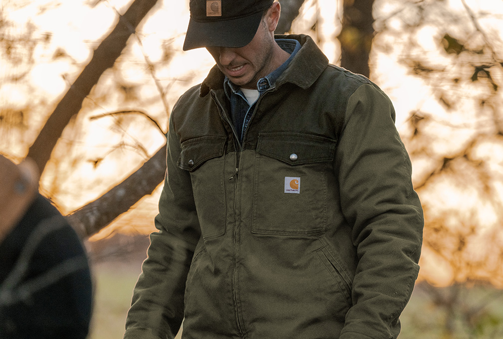 Man in een groen Carhartt overshirt in de buitenlucht