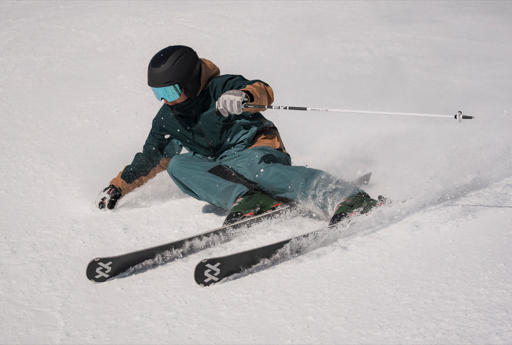 Skiër in LEKI-skikleding daalt af door de sneeuw met skistokken.