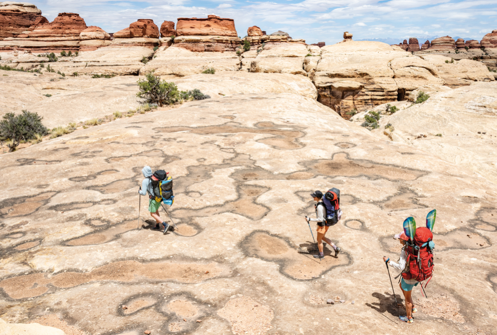 drie wandelaars lopen door een droog landschap